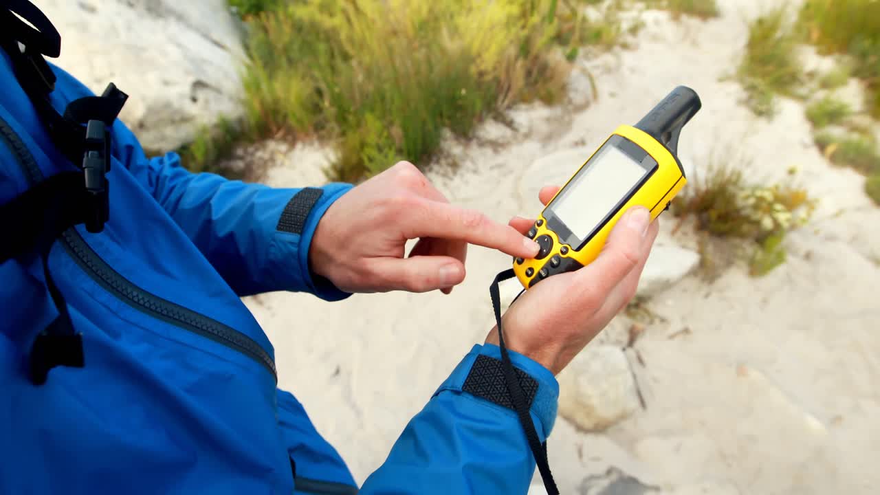 Male hiker using digital anemometer to check the weather 4k