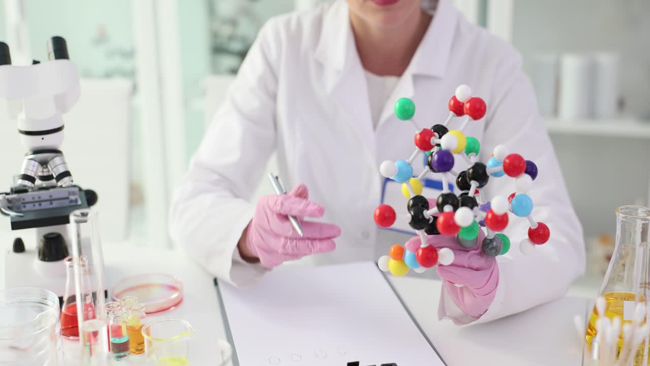 Scientist Examining Molecule Model in Lab