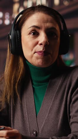 vertical video pov of focused woman sits in a campus library on a video call for a seminar