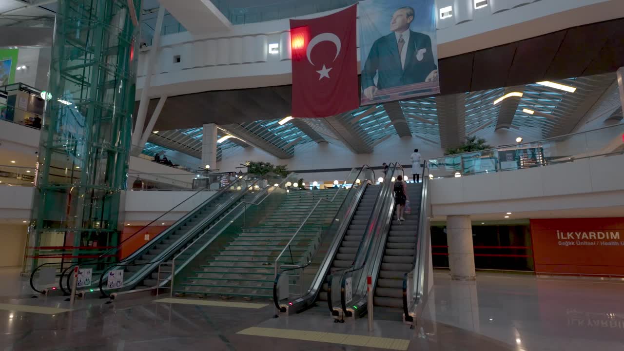 Modern Airport Interior with Escalators and Atatürk Portrait