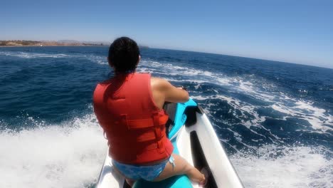 Couple-drive-a-motorboat-at-full-speed-through-the-ocean-POV