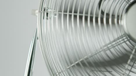 hojas de ventilador negras de un ventilador metálico frente a un fondo blanco