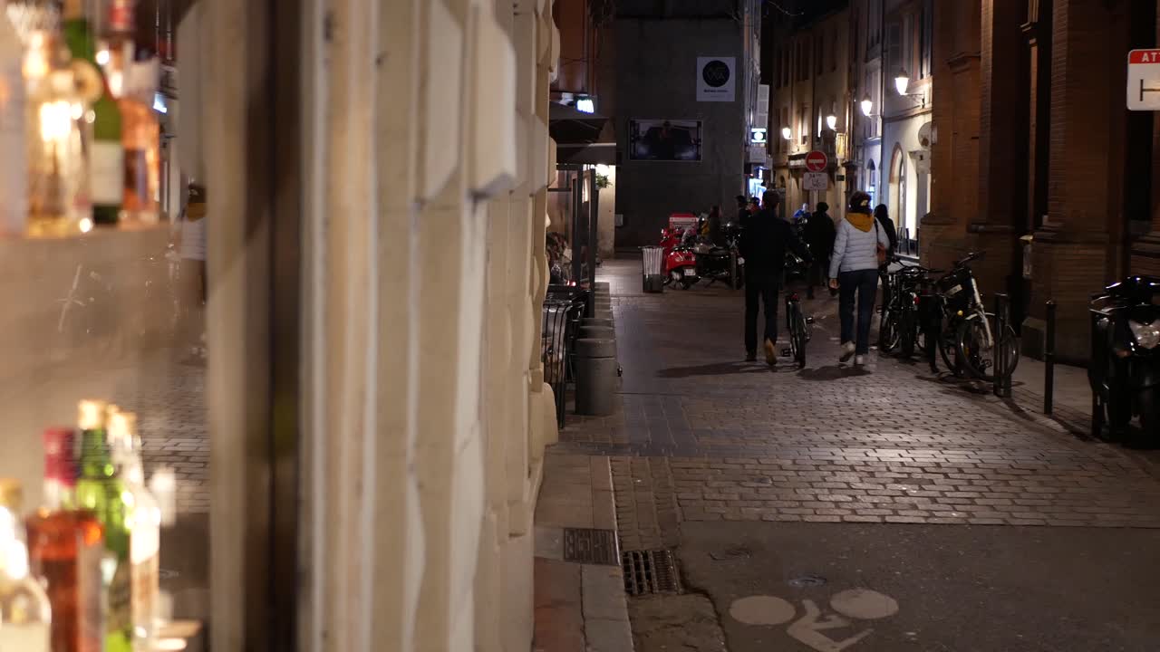 Old district at night, blurry bottles in a bar on the foreground, french city