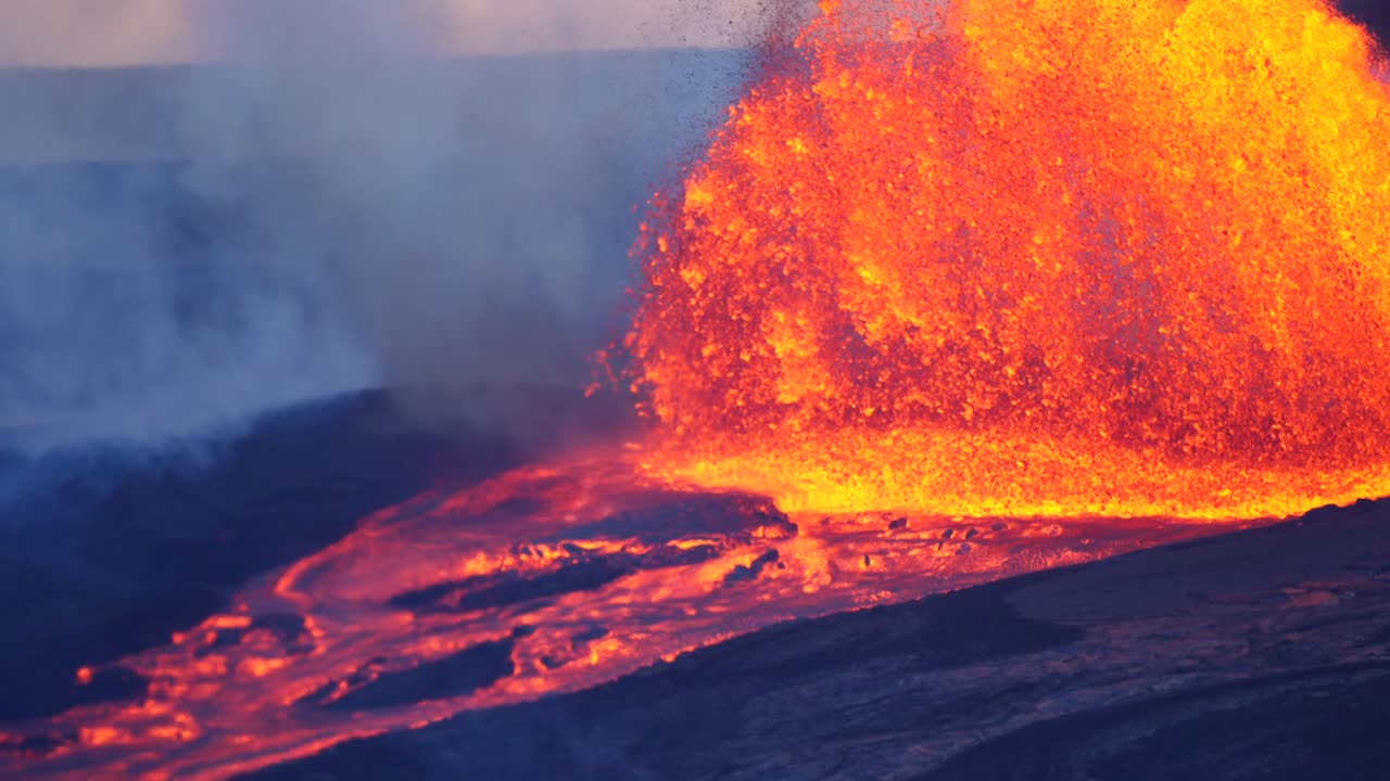 Close up slow motion footage of molten lava erupting violently into the air and flowing down from an active volcano