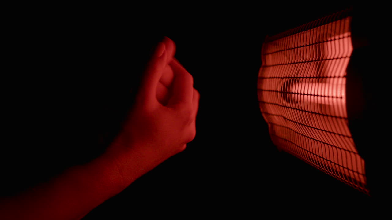 Warming Hands by Heater in the Dark