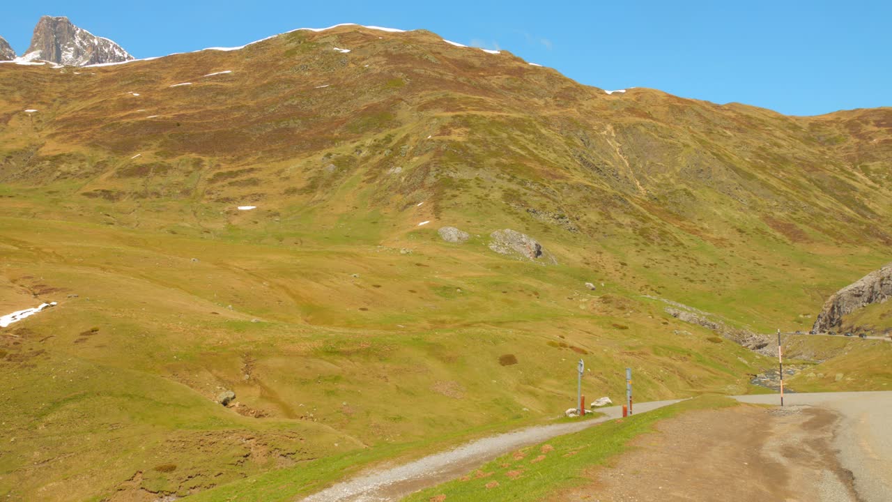 잔디로 인 경사와 휘어지는 도로가 있는 피레네 산맥의 이 나는 날