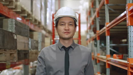 businessman in elegant clothes in warehouse walking on large corridor in factory