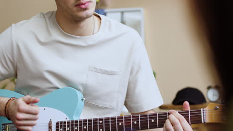 young man practising with the guitar