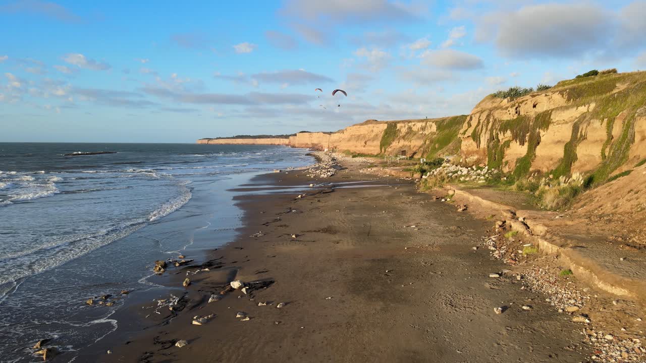 sobrevolando la playa de los acantilados con vuelos en parapente, argentina