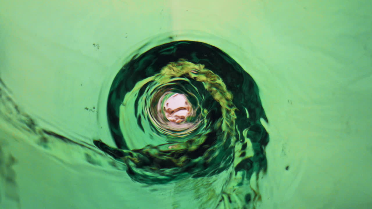 vertiendo una copa de ipa en cámara súper lenta. una corriente de cerveza que fluye en vidrio verde