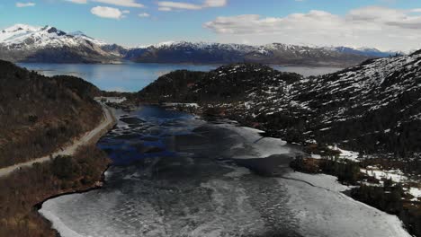 dron en aumento capturando el lago derritiéndose en un valle durante la primavera