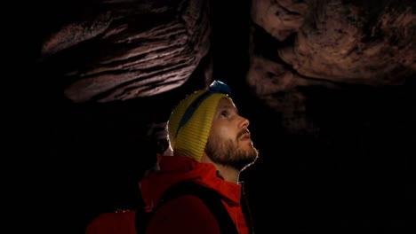 male hiker exploring a dark cave 4k