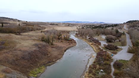 4k aerial video approaching a tiny wooden cabin on a riverbank