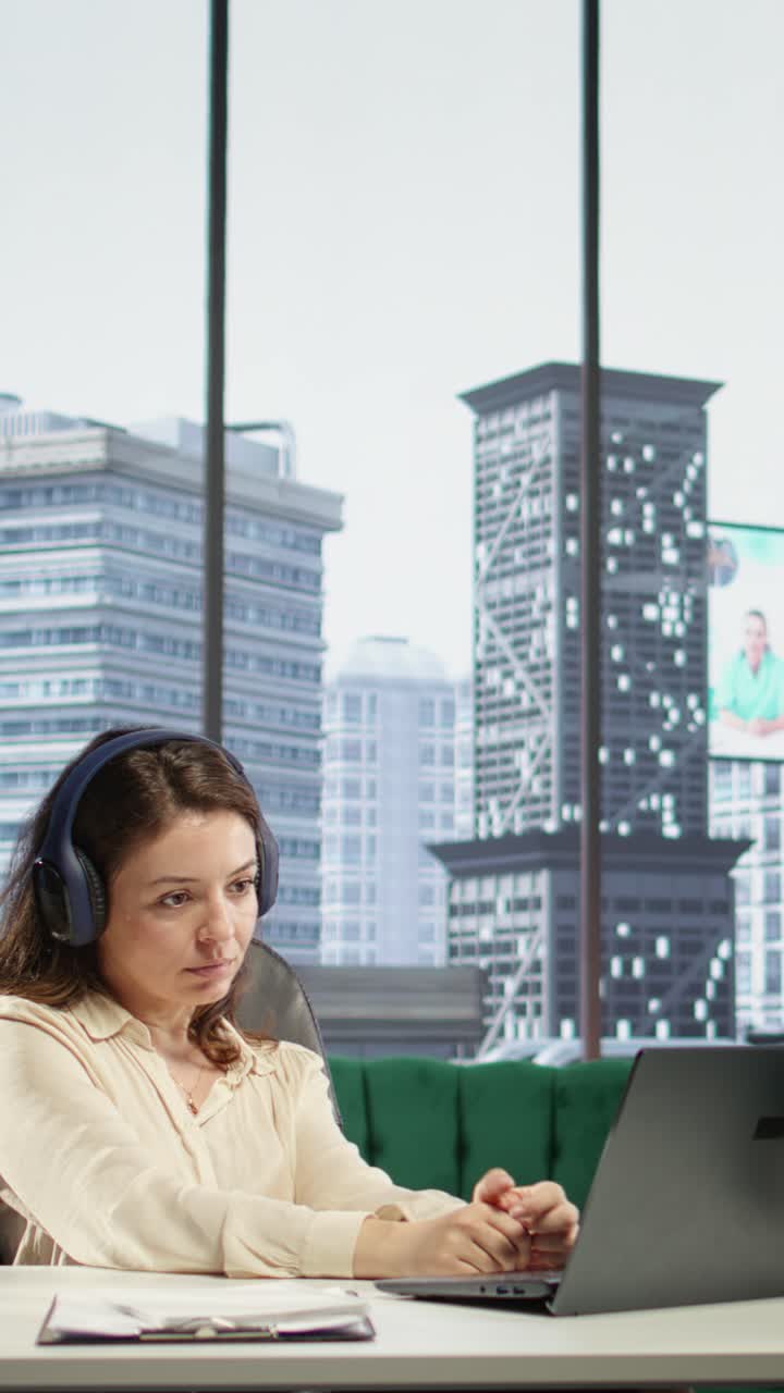 Video Vertical: Poderosa líder femenina tomando sus auriculares para la productividad en una oficina inteligente
