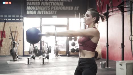 woman exercising with kettlebell in a crossfit gym