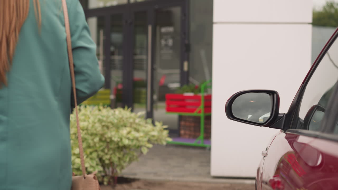 mujer elegante con bolsa de cuero en el hombro cierra la puerta del coche