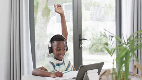 african american boy studies at home using a tablet