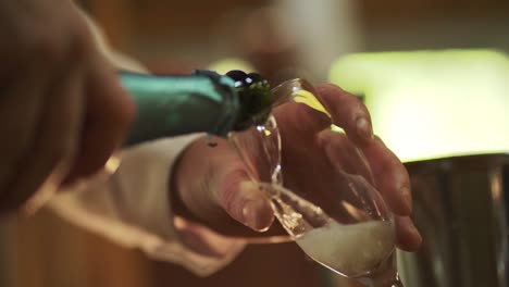 slow motion of a man pouring sparkling wine into a crystal glass