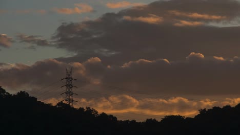 morning goldern clouds moving behind the mountain and electrical tower