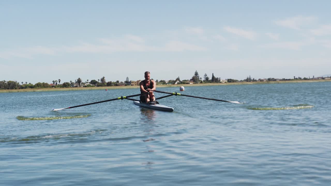 hombre caucásico mayor remando un barco en un río