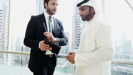 middle eastern american businessmen using tablet technology downtown