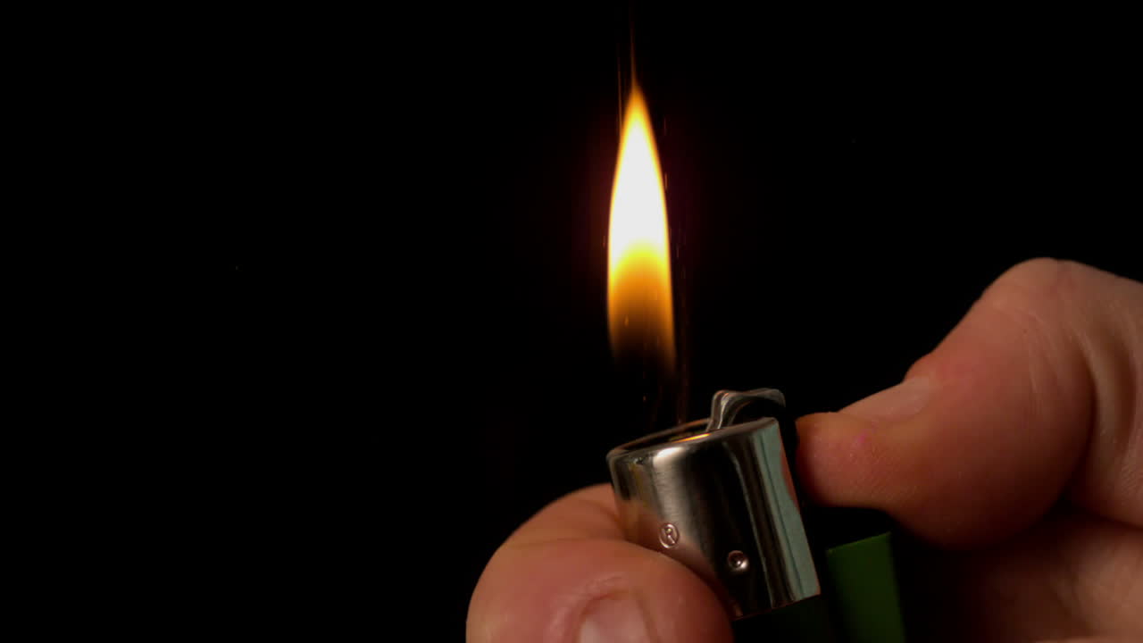 encendiendo un encendedor a mano sobre un fondo negro