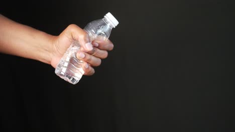 A hand holding a bottle of water