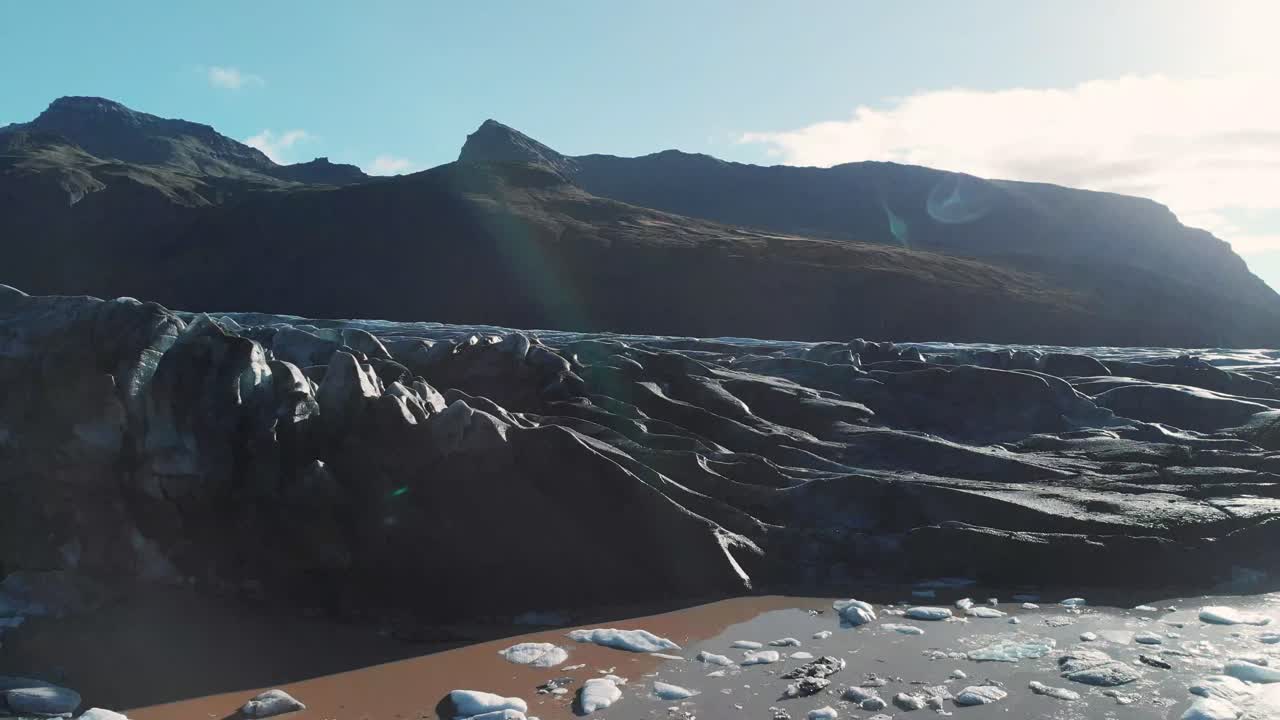 Glacial moraine and ice in a muddy pool in Skaftafell glacier, Iceland.