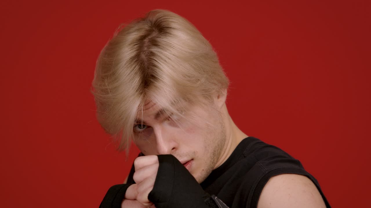 빨간 바탕에 검은 셔츠를 입은 금발의 남자