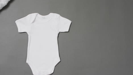 Video-of-white-baby-grow-with-copy-space-on-grey-background