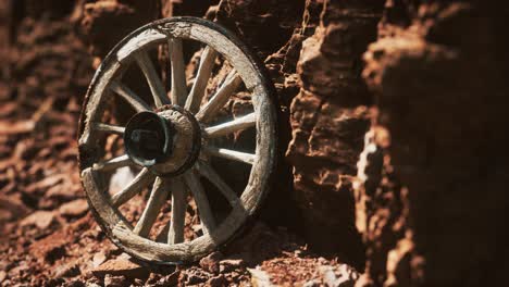 old wooden cart wheel on stone rocks