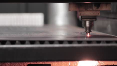 metalurgia - tecnología de corte por láser de plasma de material de chapa plana con chispas debajo - primer plano, cámara lenta