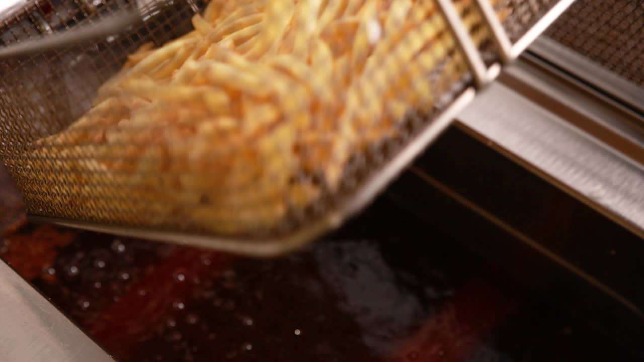 Patatine fritte in cottura in una friggitrice commerciale