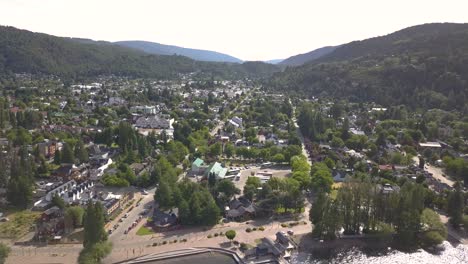 Aéreo-Sobre-Una-Hermosa-Ciudad-En-Un-Valle-Verde-En-Medio-De-Enormes-Montañas