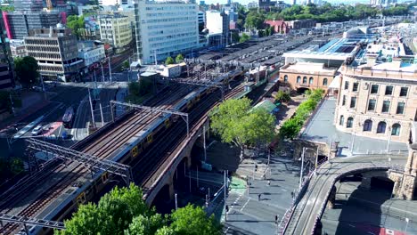 drone aerial landscape of commuter train on railway tracks line entering sydney's central station yard platform city australia transport urban travel tourism