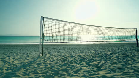 beach volleyball net at sunset on a sandy shore