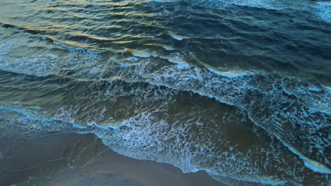 Beautiful-calm-aerial-view-of-peaceful-waves-gently-crashing-on-sandy-beach-shore