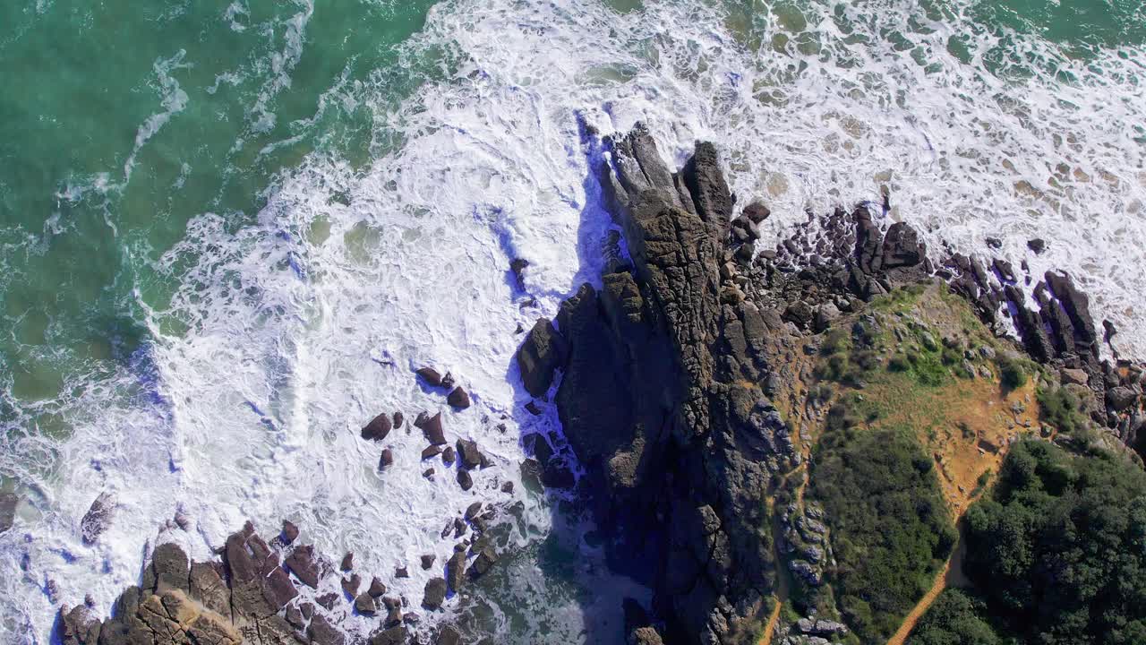 화창한 날 스페인 칸타브리아의 파도가 바위에 부딪히는 공중 샷