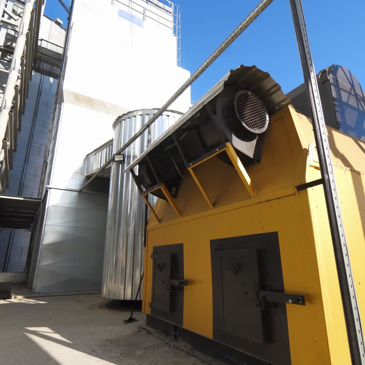 Industry outdoors. Small industrial building on a factory. Exterior of modern grain processing plant at sunny daytime