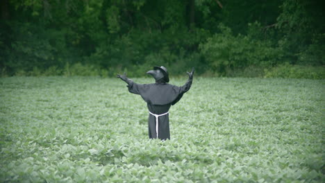 plague doctor in field with wind blowing in slow motion