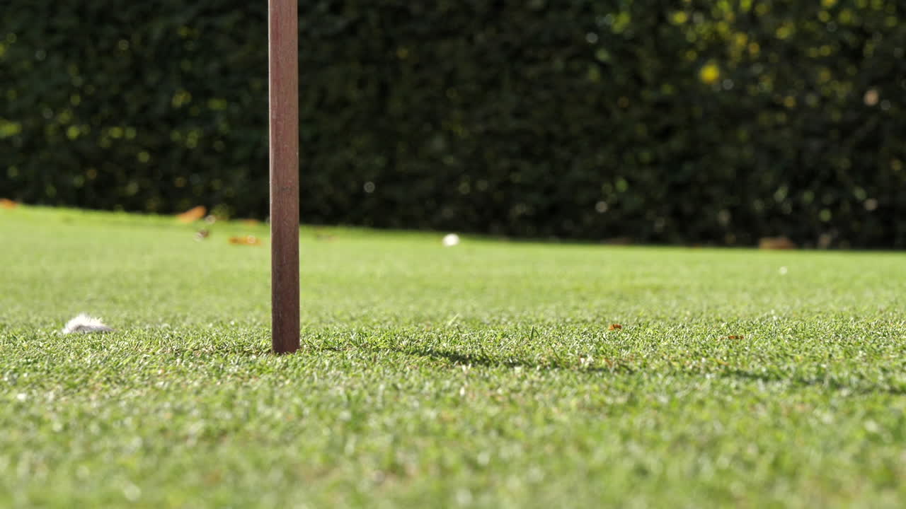 구멍으로 굴러가는 골프공