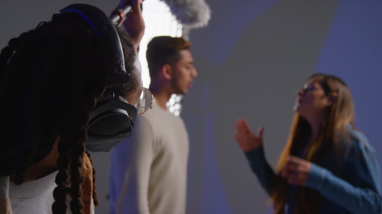 grabador de sonido masculino con actores que trabajan en el set de filmación de películas o videos en el estudio 1