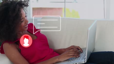 animation of people icon and speech banner over happy biracial woman using laptop