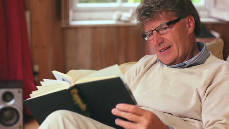 hombre maduro leyendo un libro sentado
