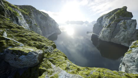 a breathtaking view of a mountain lake with clouds and fog in the background