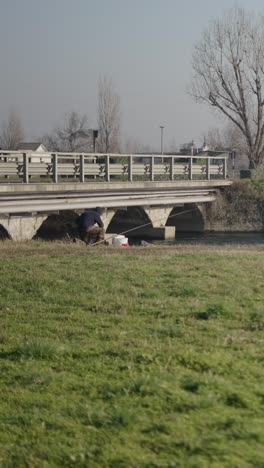 Fishing under a bridge on a sunny day