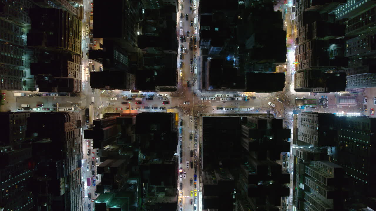 Drone top-down view of a Hong Kong intersection filled with cars and neon-lit buildings at night