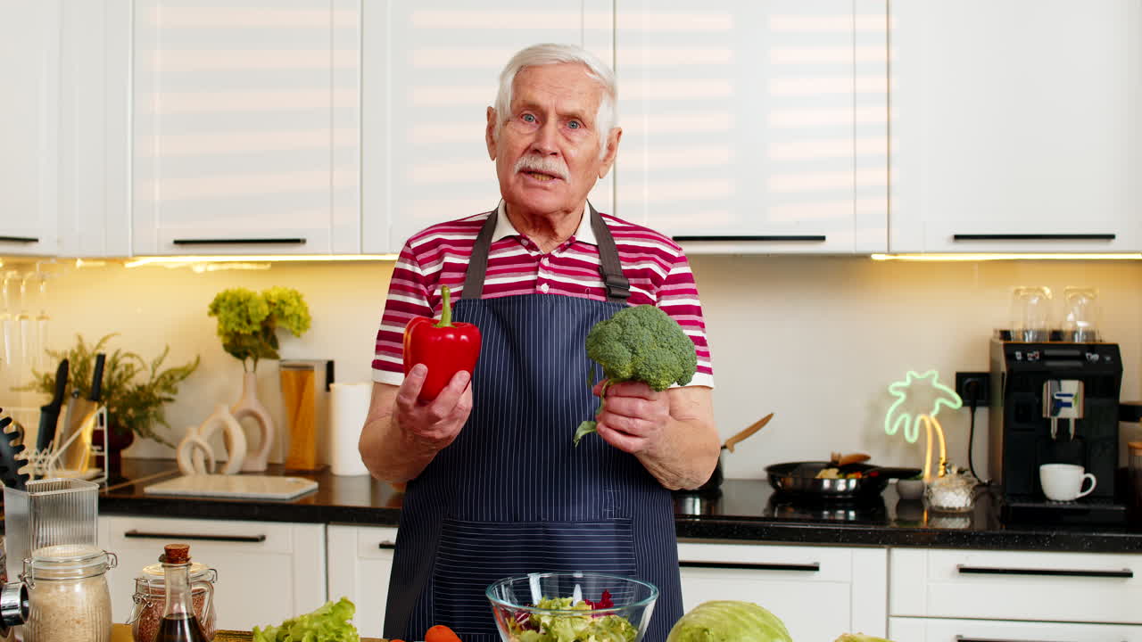Senior zeigt saisonales Gemüse in der Küche und erklärt gesunde Ernährung und Nährstoffauswahl.