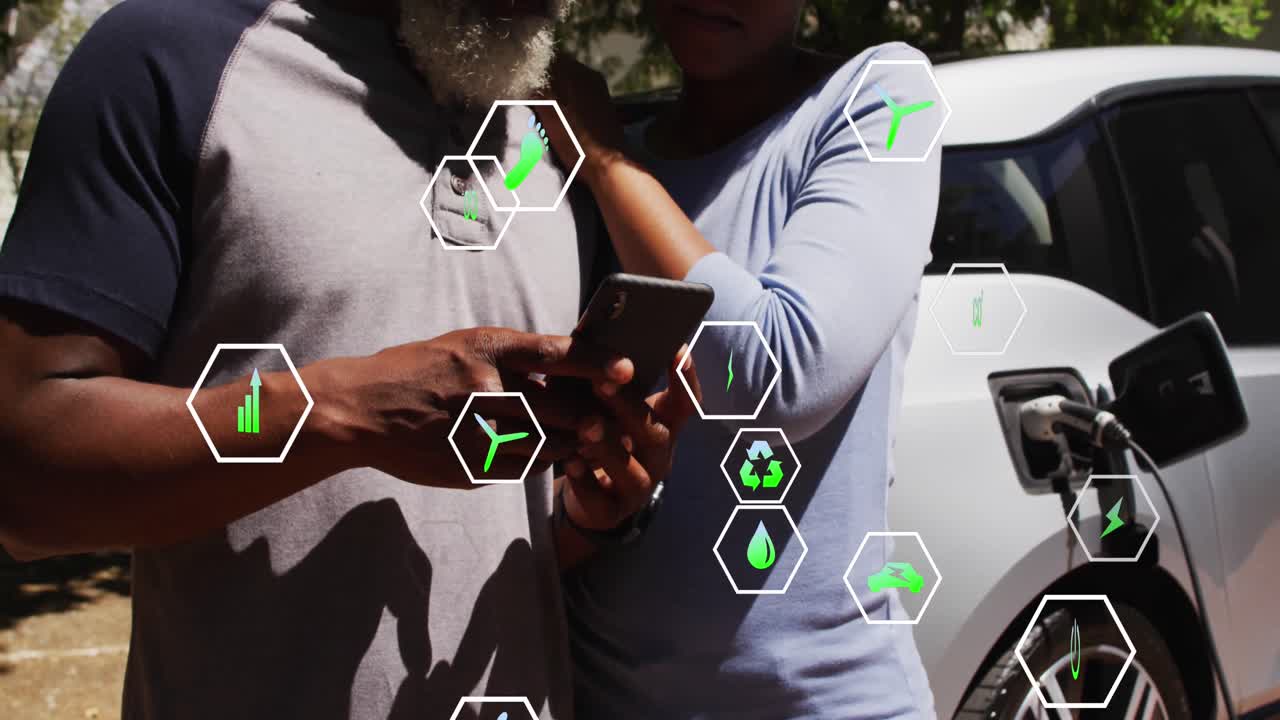 animación de iconos de ecología sobre una pareja afroamericana llenando de combustible el coche y usando un teléfono inteligente.