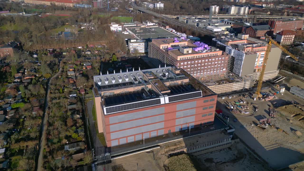 Moderne bygning med stort datacenter, der har køleenheder, solpaneler og et grønt tag for bæredygtig drift. Fantastiske droneoptagelser i fugleperspektiv